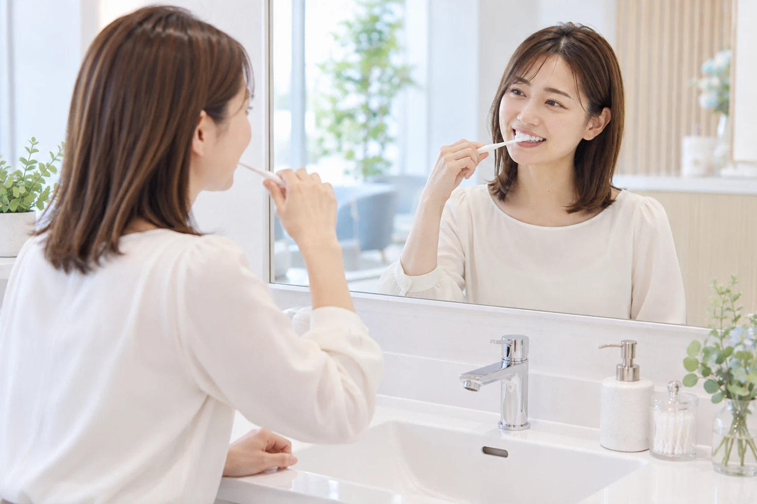 鏡を見ながら自分の歯を磨く女性モデル