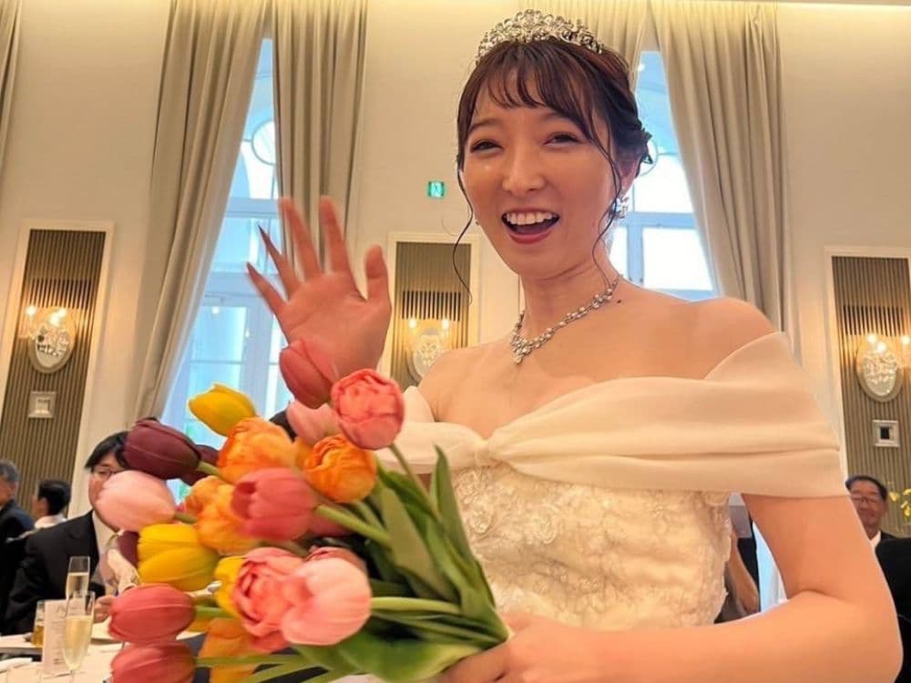 チューリップの花束を持ち、手を振る花嫁のお写真