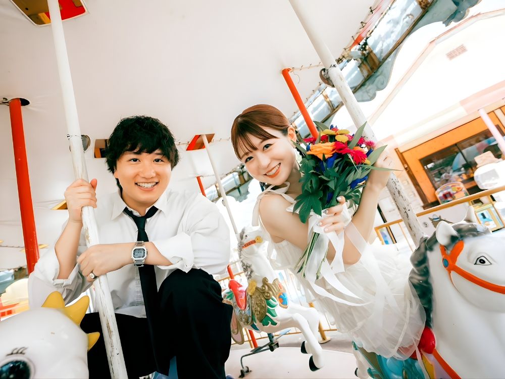 メリーゴーラウンドに乗る新郎新婦のお写真