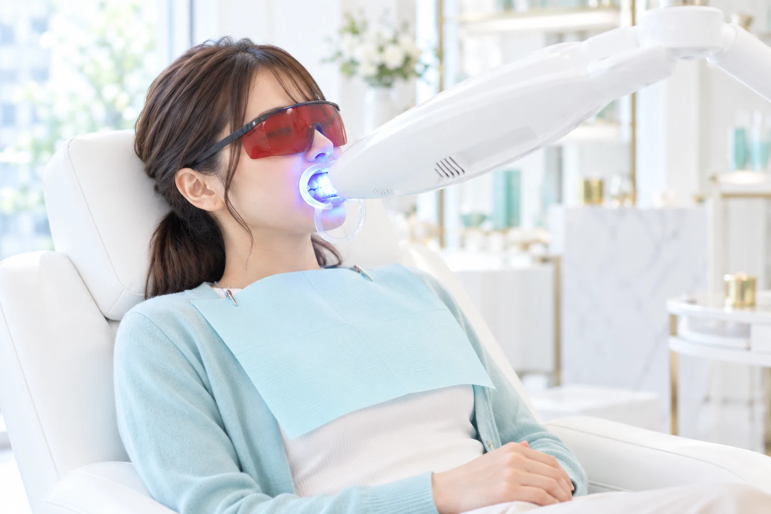 保護ゴーグルを着用し、LEDライトでケアする成人女性モデル