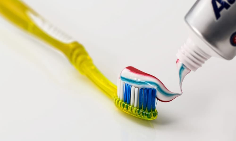 黄色い柄の歯ブラシに歯磨き粉がしぼり出されている画像