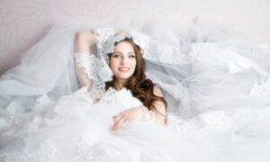 横たわる白いウェディングドレスを着た花嫁の写真