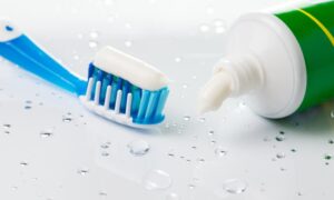 歯磨き粉が乗った歯ブラシと歯磨き粉の画像