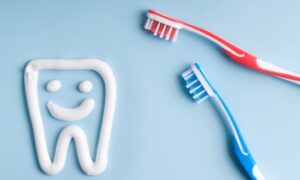 赤と青の歯ブラシと歯磨き粉で歯の絵が描かれている画像