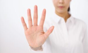 手でストップをかける女性