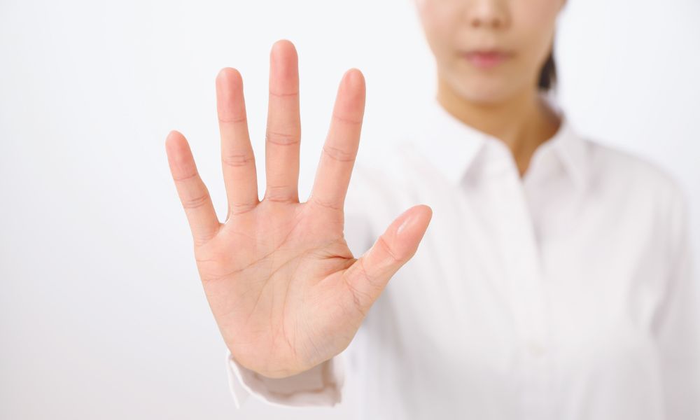 手でストップをかける女性