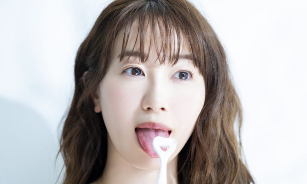 歯ブラシで舌磨きをする若い女性