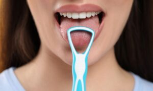 歯ブラシで舌磨きをする若い女性