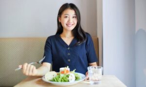 笑顔で食事をする若い女性