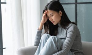 悩みうつむいている若い女性