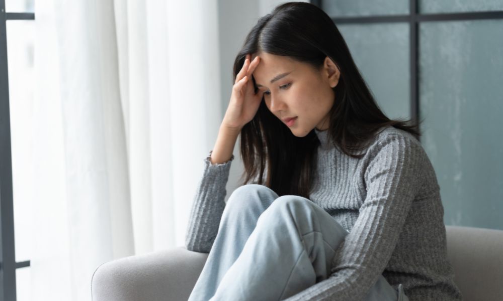 悩みうつむいている若い女性