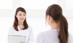 病院で受診する若い女性