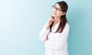 首を傾げる白衣の女性