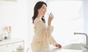 笑顔で水を飲む若い女性