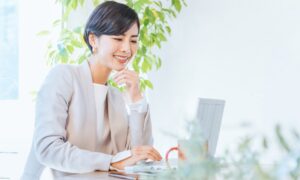 清々しい笑顔でパソコンを操作する若い女性