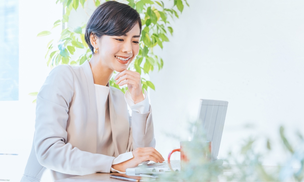 清々しい笑顔でパソコンを操作する若い女性