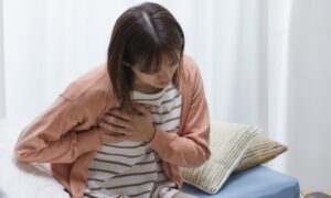 心臓を抑える若い女性