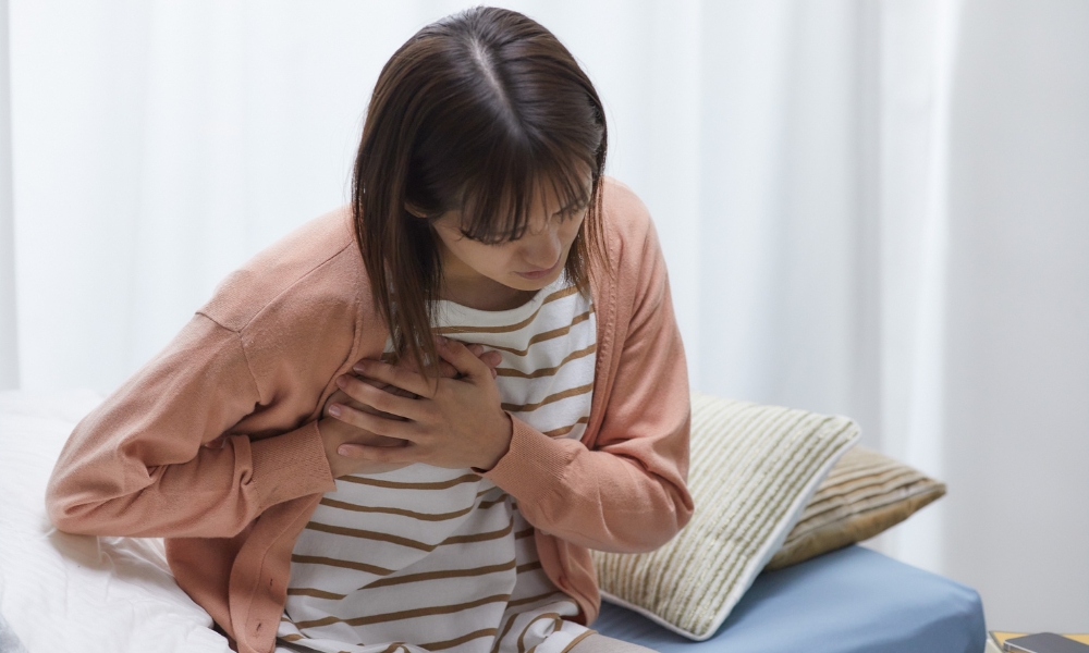 心臓を抑える若い女性