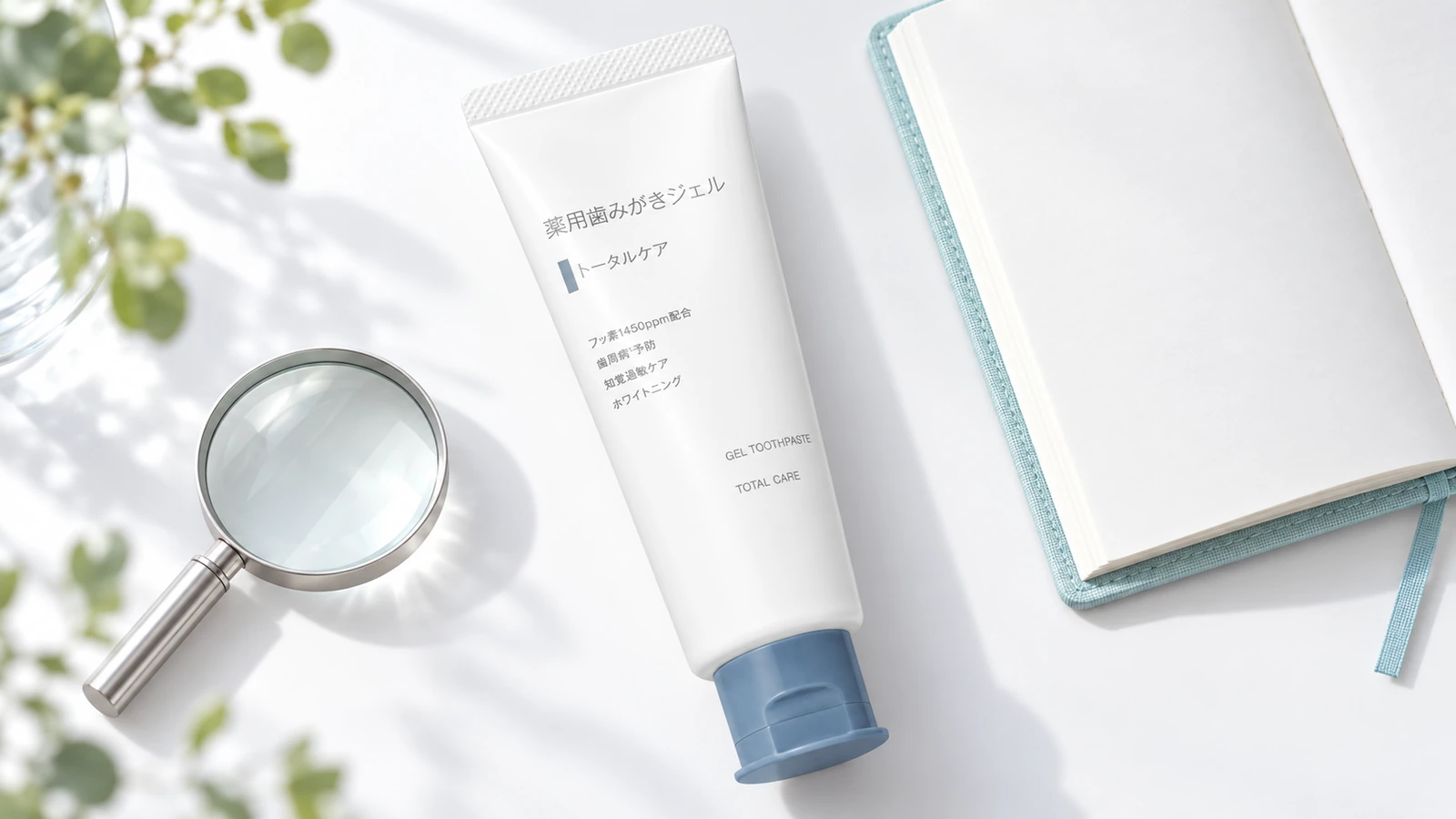 無印良品の薬用歯みがきジェルトータルケアとルーペ、ノートを置いた商品表示確認のイメージ